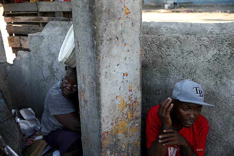Порт-о-Пренс, Гаити. Люди укрываются от выстрелов во время покушения на президента страны Жовенеля Моиза. Стрельба началась во время торжественной церемонии в честь 212-й годовщины смерти основателя Гаити Жан-Жака Дессалина 