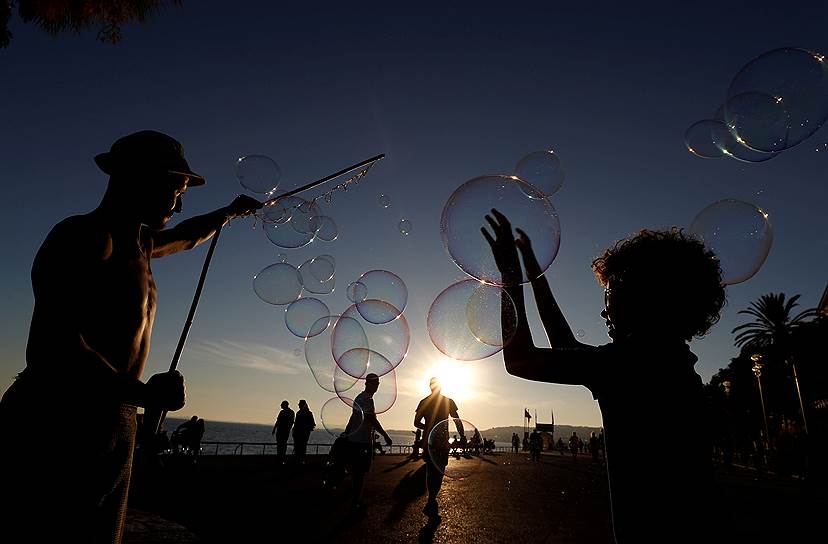 Ницца, Франция. Уличные артисты пускают мыльные пузыри на Английской набережной 