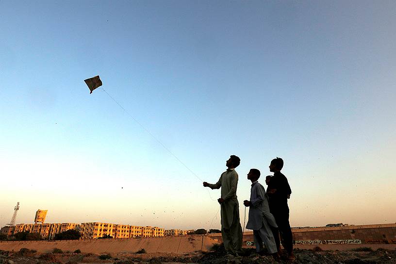 Карачи, Пакистан. Дети запускают воздушного змея около реки