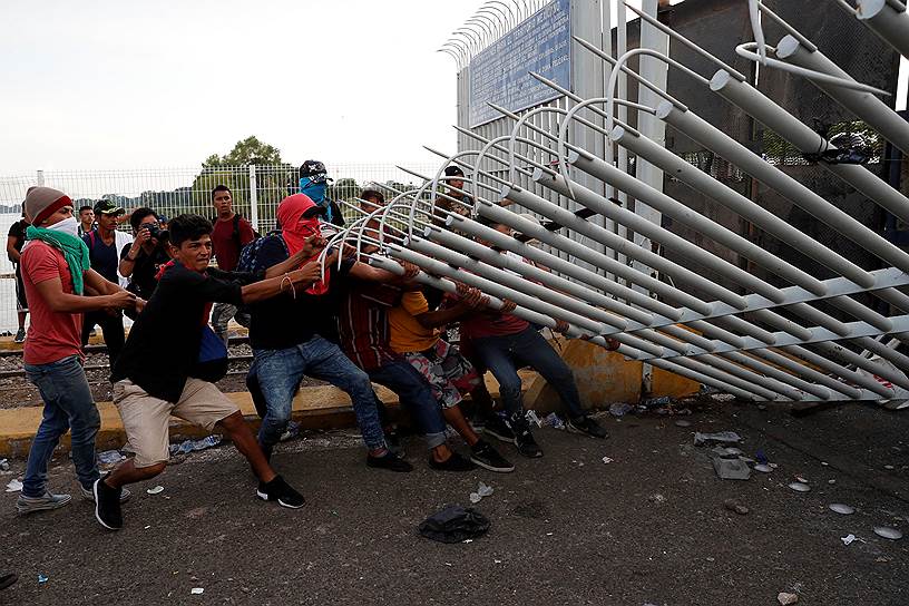 Текун Уман, Гватемала. Мигранты валят забор на границе с Мексикой, чтобы продолжить путь в США