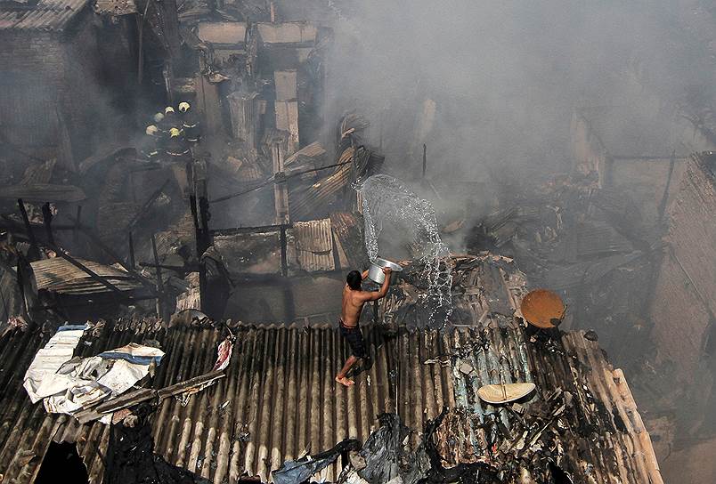 Мумбай, Индия. Местный житель тушит пожар 
