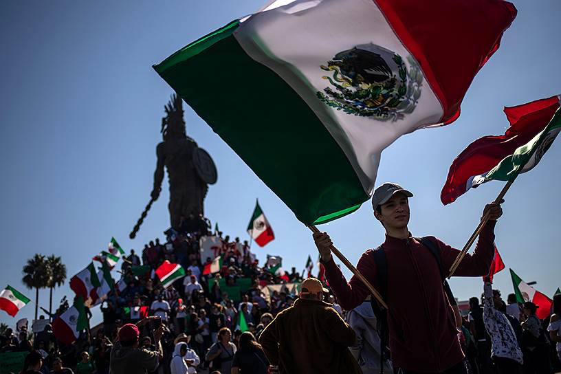 Тихуана, Мексика. Мальчик машет флагом на протестной акции против мигрантов из Центральной Америки