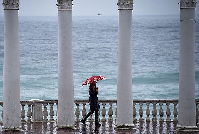 Крым. Девушка с зонтиком на набережной во время шторма