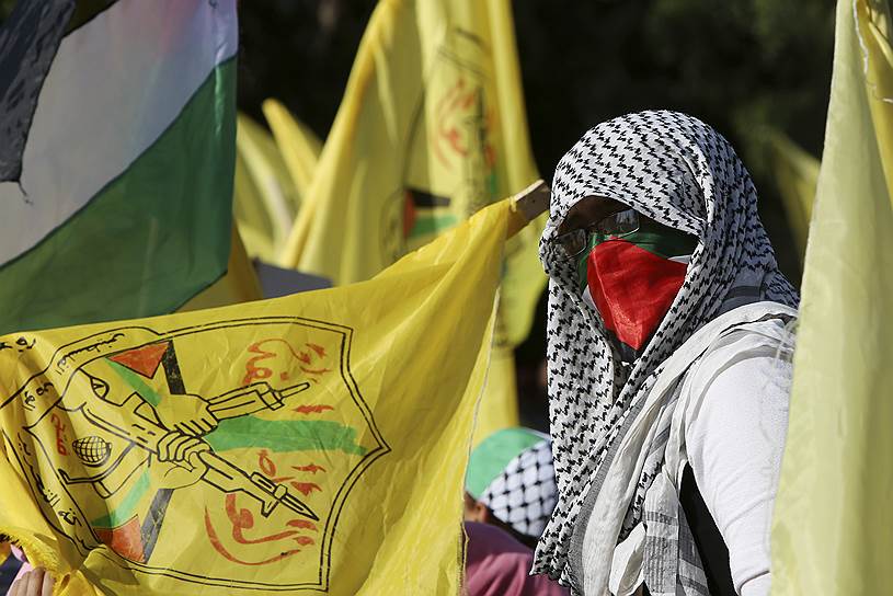 Сектор Газа. Палестинцы с флагами партии ФАТХ во время шествия по случаю 14-й годовщины кончины Ясира Арафата 
