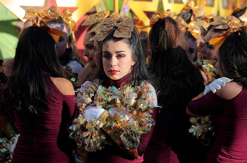 Участница парада пятается согреться во время парада в честь Дня благодарения 