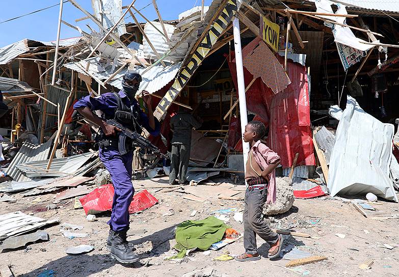 Могадишо, Сомали. Сотрудник спецслужб осматривает место взрыва на рынке