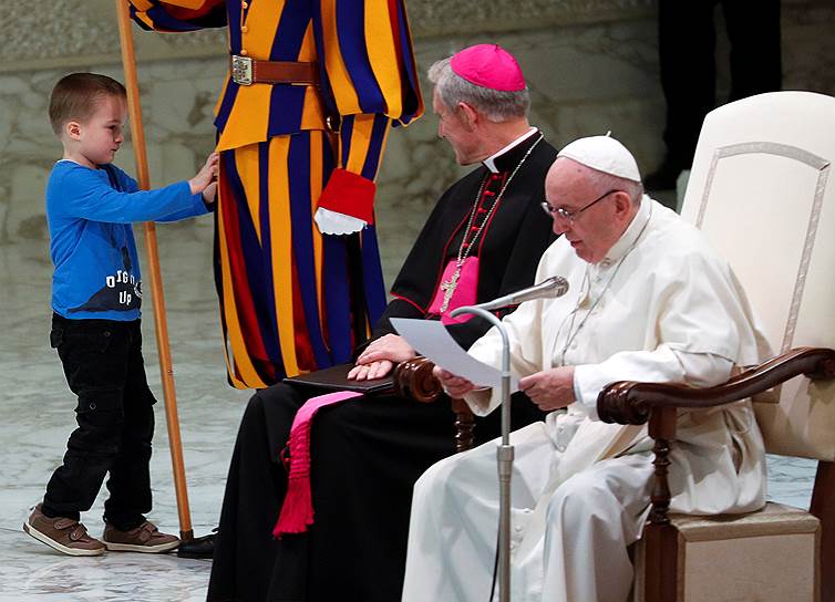 Ватикан. Мальчик трогает гвардейца во время аудиенции папы римского Франциска