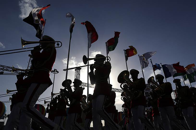 Каир, Египет. Музыканты военного оркестра маршируют на фоне флагов стран-участниц выставки вооружений
