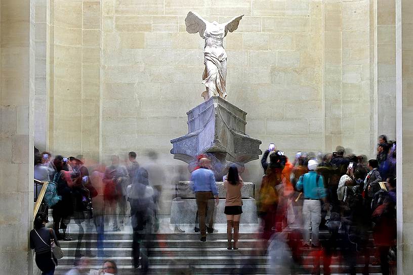 Париж, Франция. Посетители Лувра осматривают древнегреческую мраморную скульптуру богини Ники 