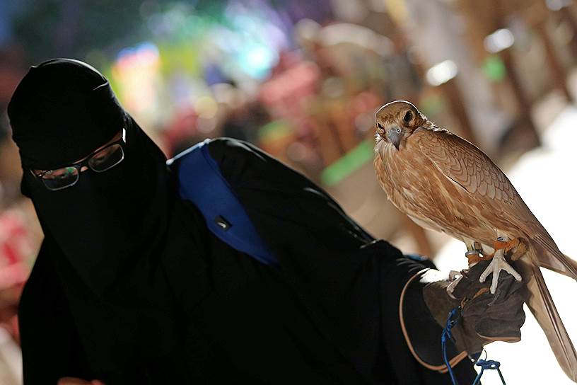 Эр-Рияд, Саудовская Аравия. Женщина держит сокола на выставке птиц для охоты