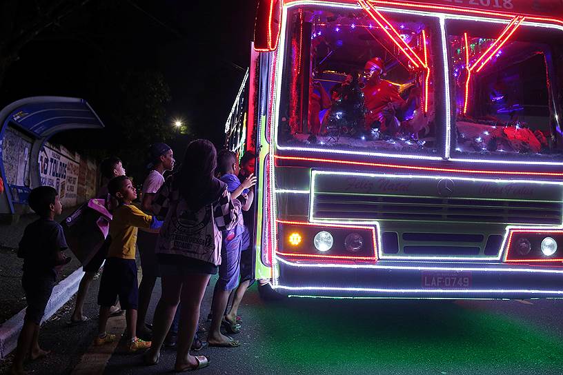 Санту-Андре, Бразилия. Дети садятся в автобус, украшенный к Новому году