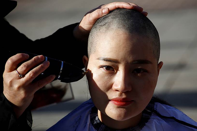 Пекин, Китай. Супруга правозащитника Вана Юнхана бреет голову в знак протеста против жестого обращения со своим мужем в тюрьме 