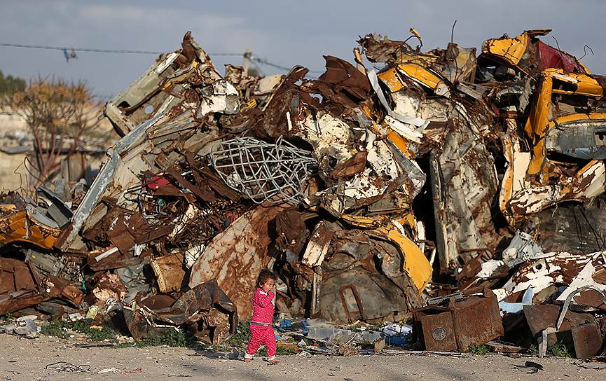 Хан-Юнис, сектор Газа. Девочка идет вдоль горы с металлоломом