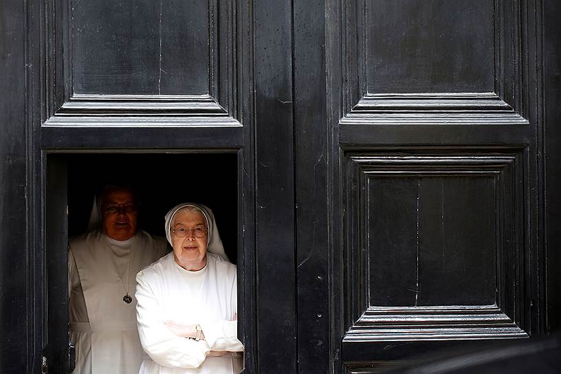 Иерусалим, Израиль. Католические монахини выглядывают из здания 