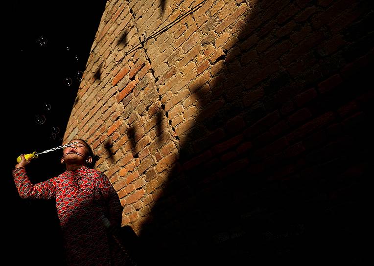 Лалитпур, Непал. Девочка пускает мыльные пузыри 
