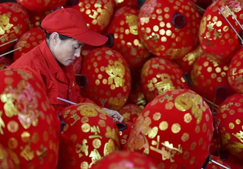 Уезд Уи, провинция Чжэцзян, Китай. Работница фабрики готовит украшения на Китайский Новый год