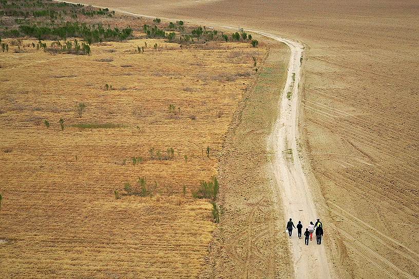 Пенитас, штат Техас, США. Беженцы идут по дороге после пересечения реки Рио-Гранде