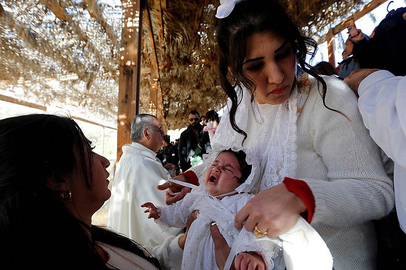 Иордания. Беженцы из Ирака во время крещения в храме Иоанна Крестителя
