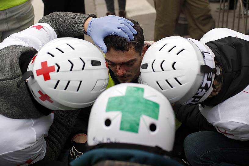 Волонтеры оказывают первую помощь пострадавшим демонстрантам в Париже. 