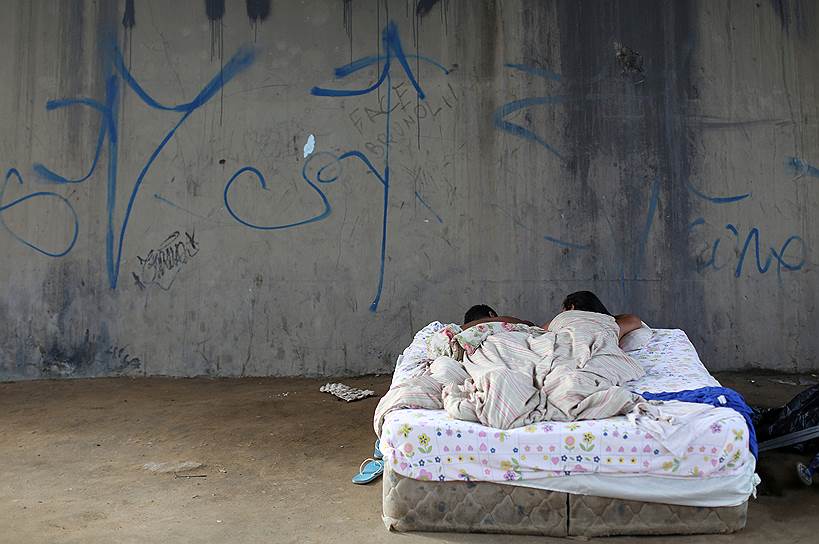 Манаус, Бразилия. Пара из Венесуэлы спит около автобусной остановки