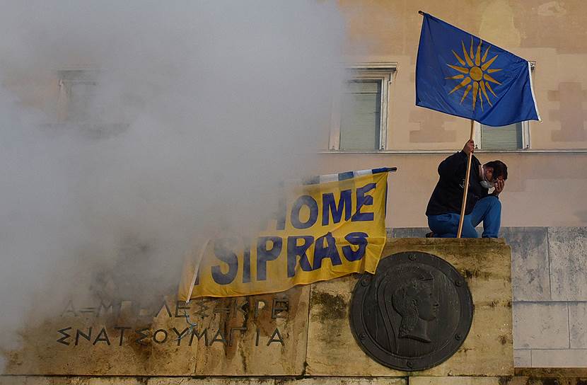 Протестующий держит флаг с Вергинской звездой - эмблемой античного греческого государства Македония и Александра Македонского
