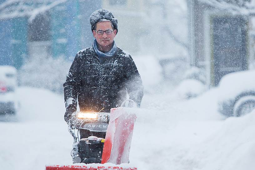 Буффало, Нью-Йорк. Местный житель чистит дорогу во время снегопада