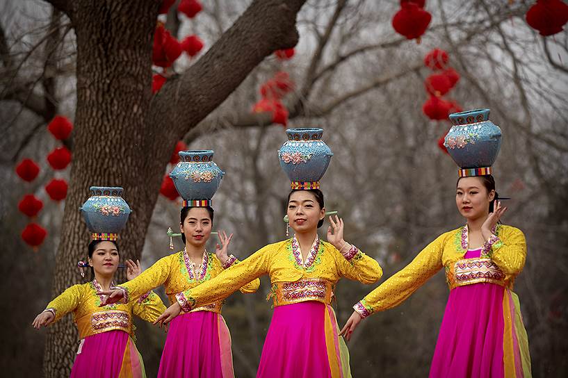 Пекин, Китай. Женщины в традиционной одежде танцуют на ярмарке