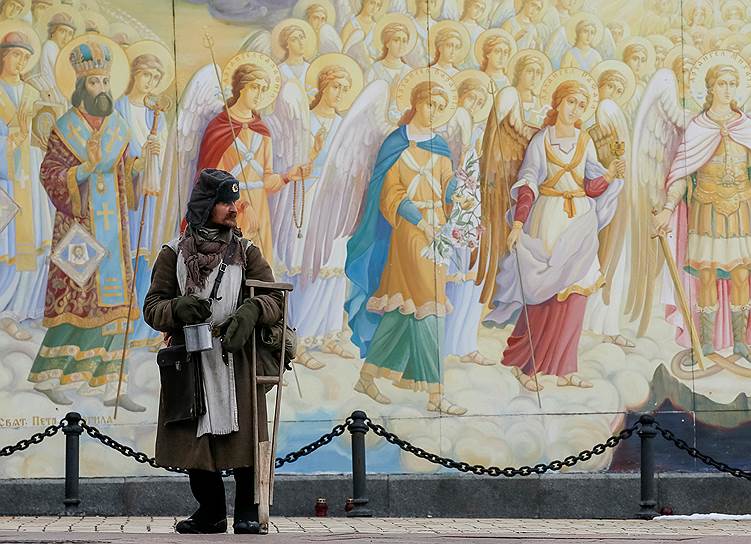 Киев, Украина. Мужчина в форме солдата Красной армии просит милостыню у Михайловского Златоверхого монастыря