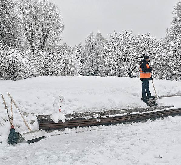 Дворник во время расчистки снега в парке
