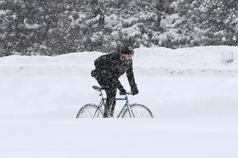 Оттава, Канада. Мужчина катается на велосипеде во время снежной бури