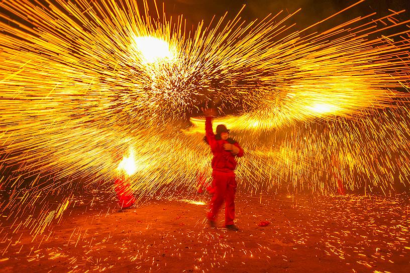 Лучжоу, КНР. Артист выступает в канун китайского праздника фонарей