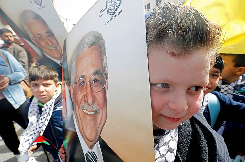 Наблус, Западный берег реки Иордан. Палестинский мальчик держит фотографию президента Махмуда Аббаса на митинге в его поддержку