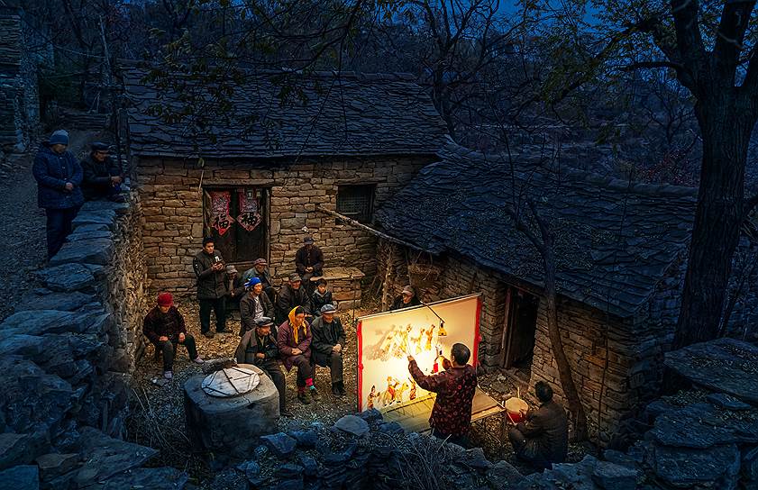 Артисты театра теней выступают в китайской деревне 