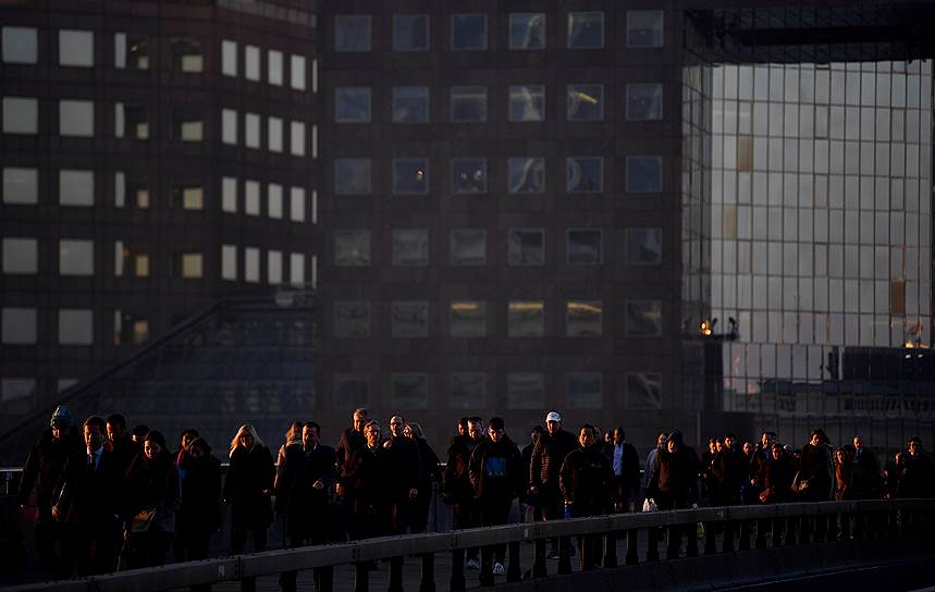 Лондон, Великобритания. Местные жители пересекают Лондонский мост в час пик