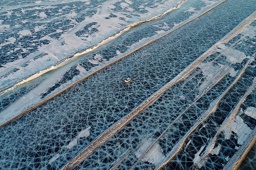 Красноярск, Россия. Автомобиль едет по дороге, проложенной по льду реки Енисей