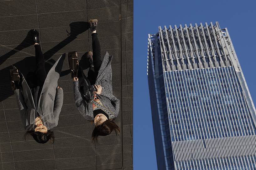 Пекин, Китай. Женщины в отражении панелей здания французского люксового бренда Louis Vuitton
