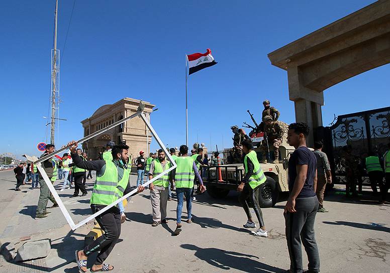 Басра, Ирак. Демонстрант держит рамку во время акций протеста 