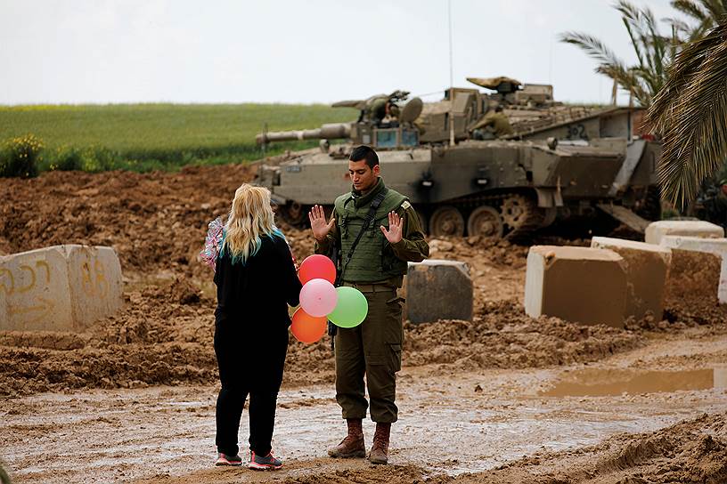 Израиль. Женщина дарит воздушные шары израильскому солдату на границе с сектором Газа