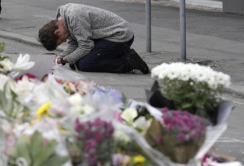 Крайстчерч, Новая Зеландия. Скорбящий по жертвам массового убийства молится возле мечети