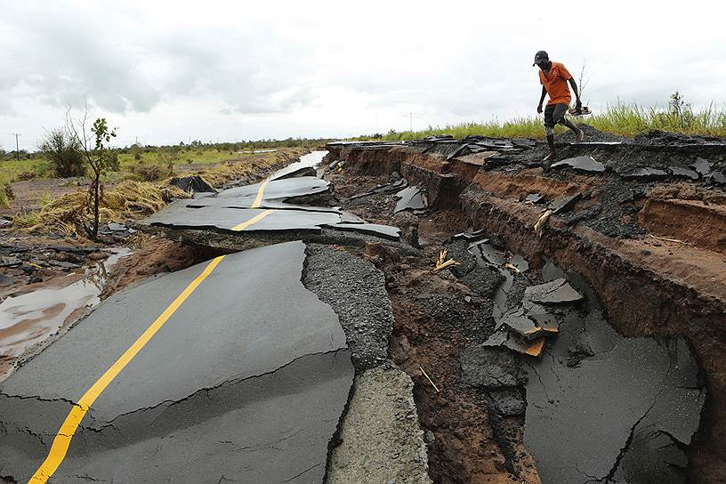 Нхаматанда, Мозамбик. Мужчина проходит через участок дороги, поврежденный циклоном Идай