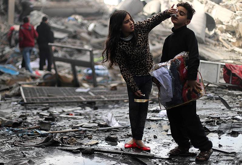 Газа, Палестина. Девочка очищает лицо своего брата после обстрела Израилем объектов «Хамаса»