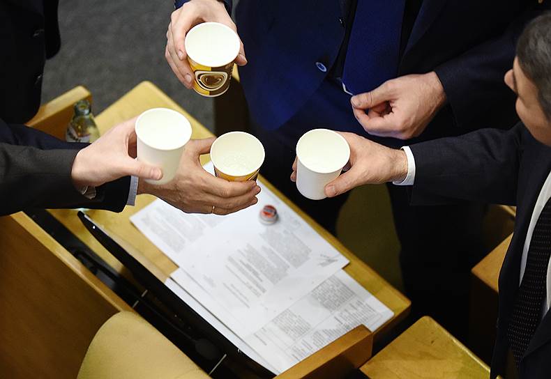 21 марта, Москва. Депутаты чокаются стаканчиками с водой во время пленарного заседания