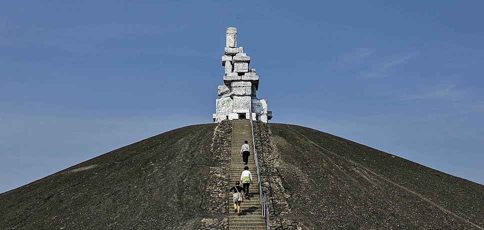 Гельзенкирхен, Германия. Люди поднимаются на холм, на котором установлена скульптурная композиция