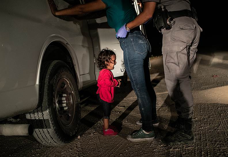 Победитель в категории «Лучший снимок года». Плачущая девочка-мигрант, чью мать задерживают на границе Мексики и США