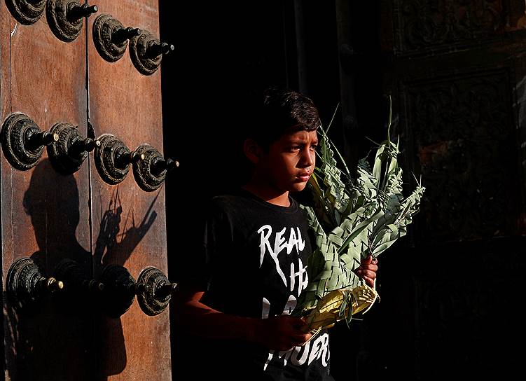 Лима, Перу. Мальчик у церкви продает пальмовые листья во время Вербного (пальмового) воскресенья