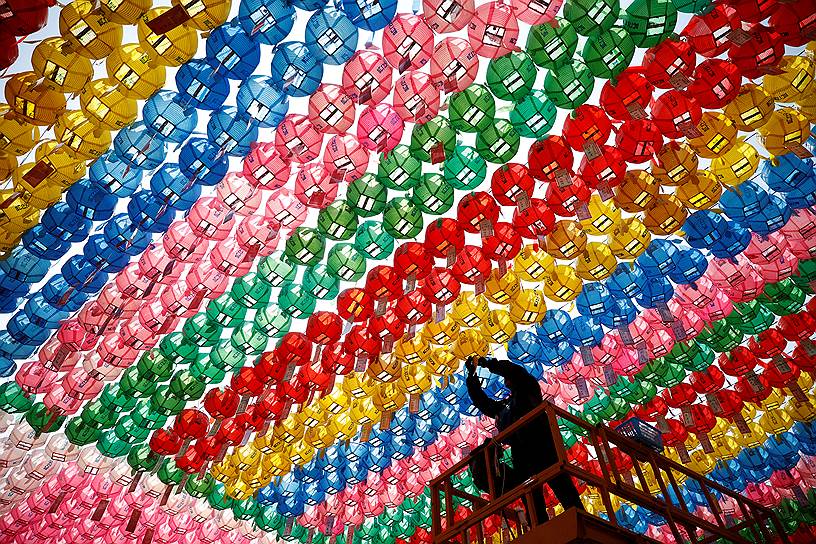 Сеул, Южная Корея. Рабочий прикрепляет молитвенные прошения с именами к фонарям в рамках подготовки к предстоящему Дню рождения Будды