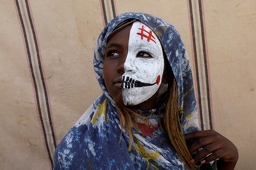 Хартум, Судан. Местная жительница наблюдает за демонстрацией у здания министерства обороны