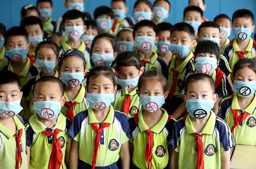Линьи, Китай. Школьники в масках на мероприятии, приуроченном к Всемирному дню без табака 