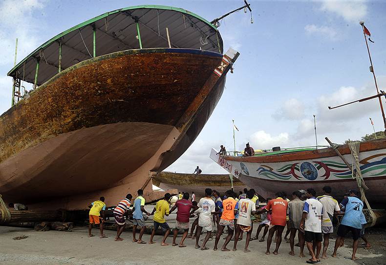 Мумбаи, Индия. Рыбаки затаскивают лодку на берег