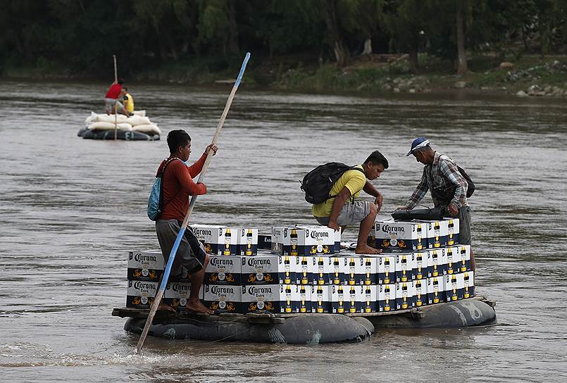 Сьюдад-Идальго, Мексика. Мужчины перевозят ящики пива через реку на самодельном плоту